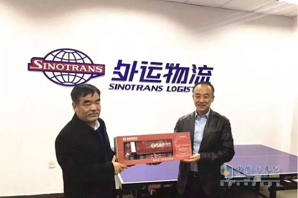 東風商用車有限公司副總經(jīng)理孫振義向中國外運物流發(fā)展有限公司總經(jīng)理李軍贈送東風天龍車模